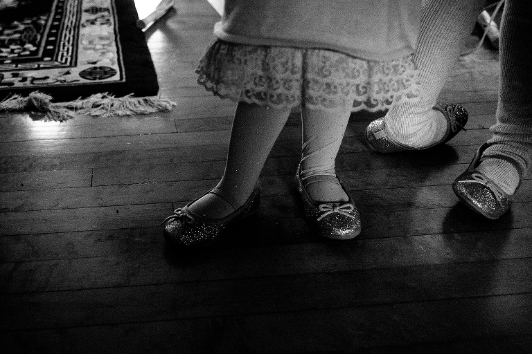 Black and white. Two little girls wearing matching sparkly shoes