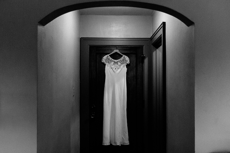 Black and white. Wedding dress hanging up in hallway