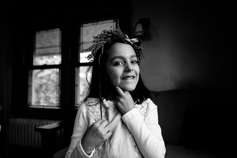 Black and white. little girl wearing flower crown gets ready for a wedding