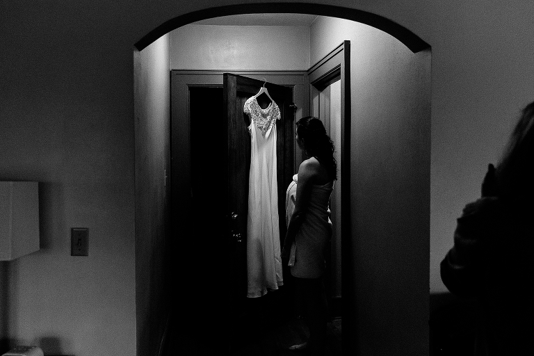 Black and white, Bride looks at her wedding dress before putting it on on her wedding day