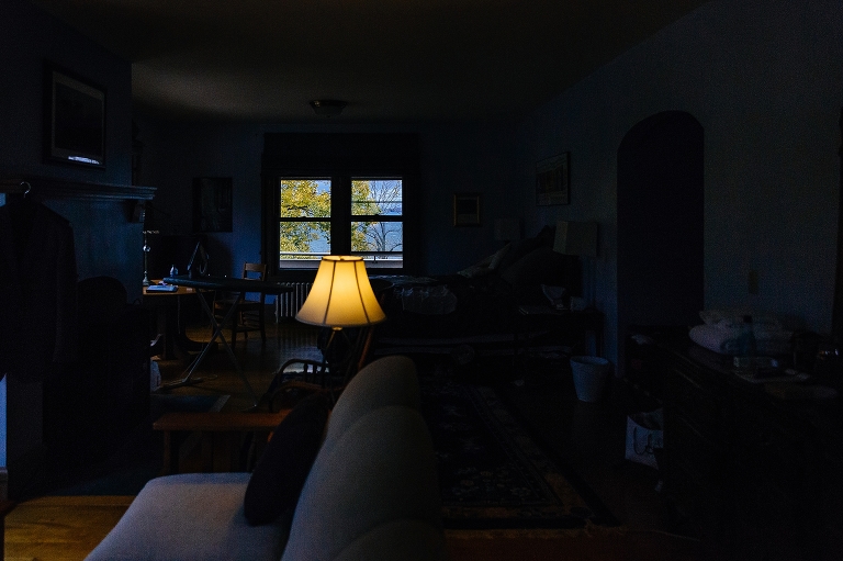 Dark room looking out on lake, lamp on