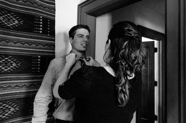 Black and white. Woman helps put on mans tie