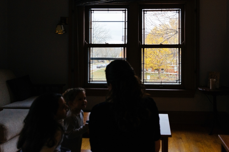 Bride and two kids sit together looking out bright windows