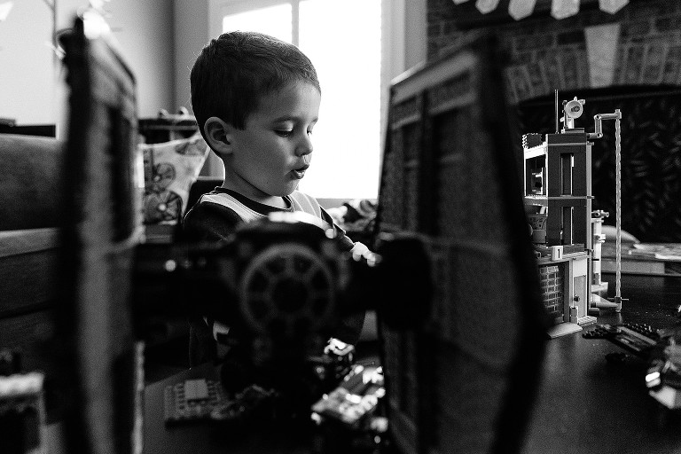 Black and white. Lego Tie Fighter frames boy.