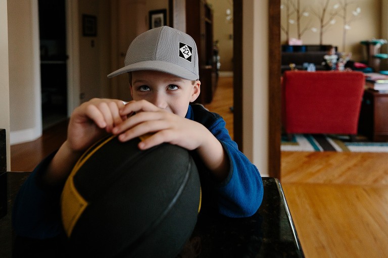 Older boy waits to go outside and play basketball 