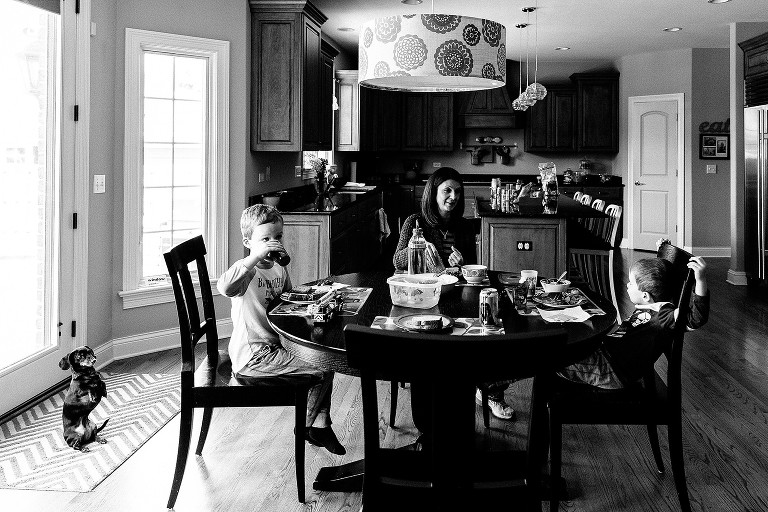 Mom, dog, and two boys talking in the kitchen