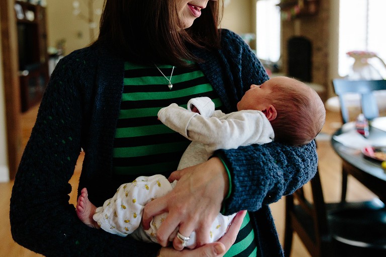 Mom holds newborn daughter in the kitchen 