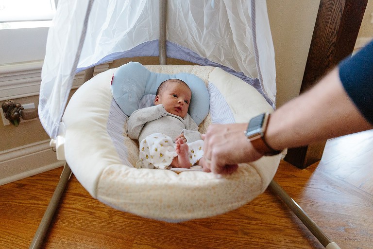 Dad checks on baby in swing 