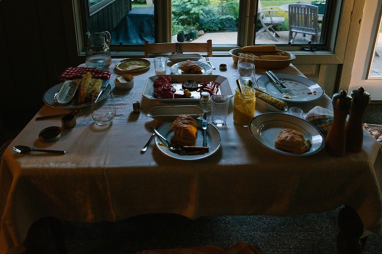 The remnants of the dinner table. The light is low and the the table offers lots of shadows and highlights of a finished meal. 