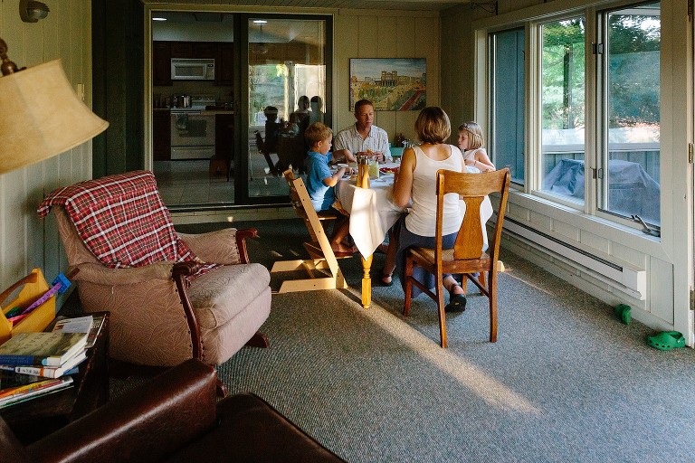 Family of four sit at the dinner table and eat. 