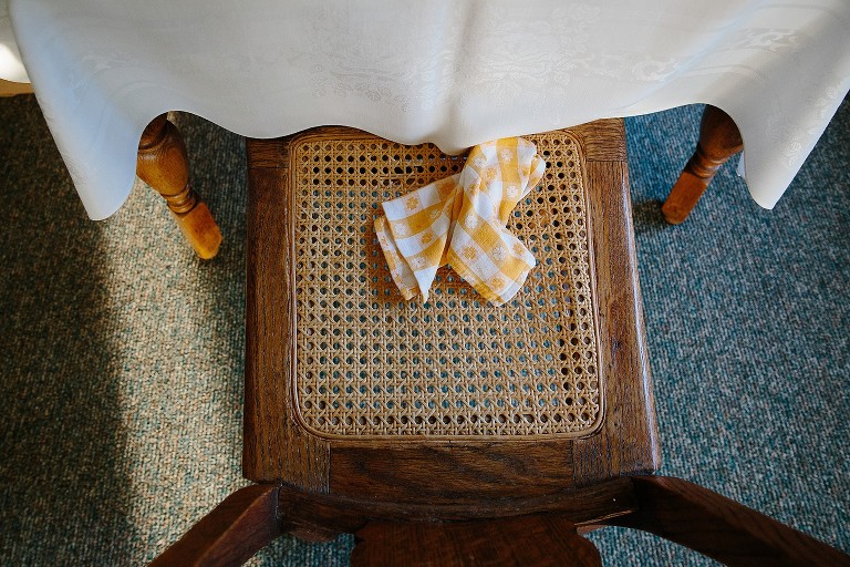 Top down view of chair with tiny circle holes and a napkin with  squares laid on top. 