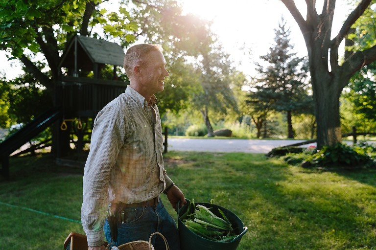 Dad carries baskets of shucked corn. 