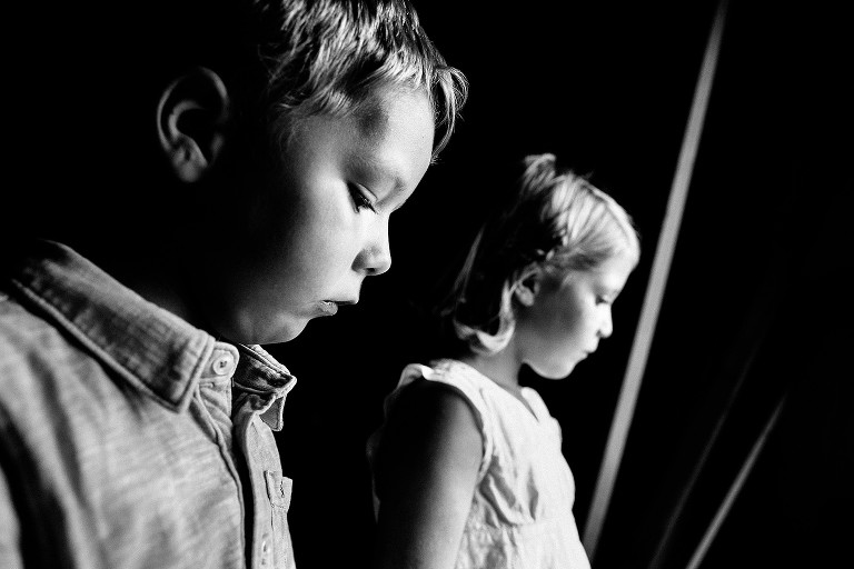 Black and white profile of two young kids looking down.