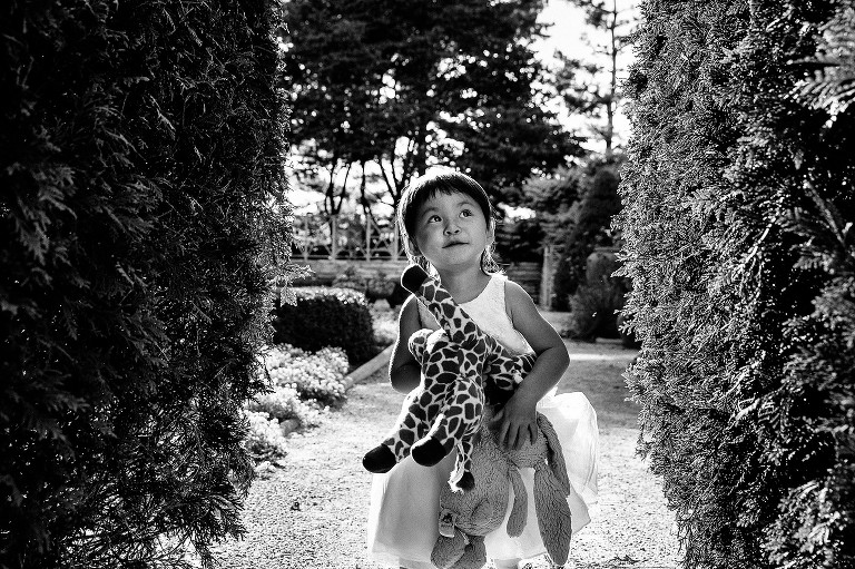 daughter holds stuffed animals in the garden