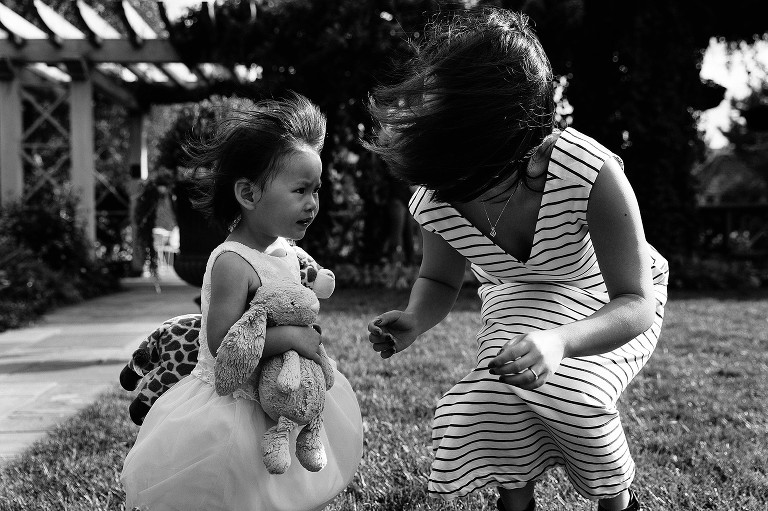 The wind blows mom's and daughter's hair at the park 