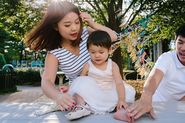 Both parents touch daughter's foot while playing a game.