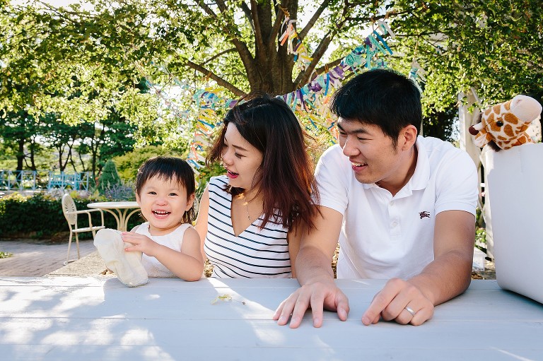 Happy family of. three sits on the park bench 