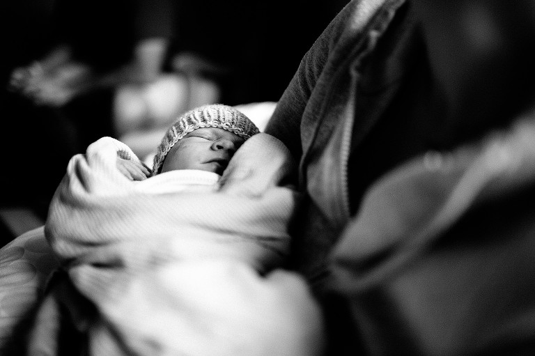 black and white. sleeping newborn in mother's arms at the hospital