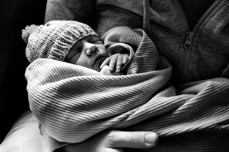 Black and white. Tight shot of sleeping newborn and fingers. 