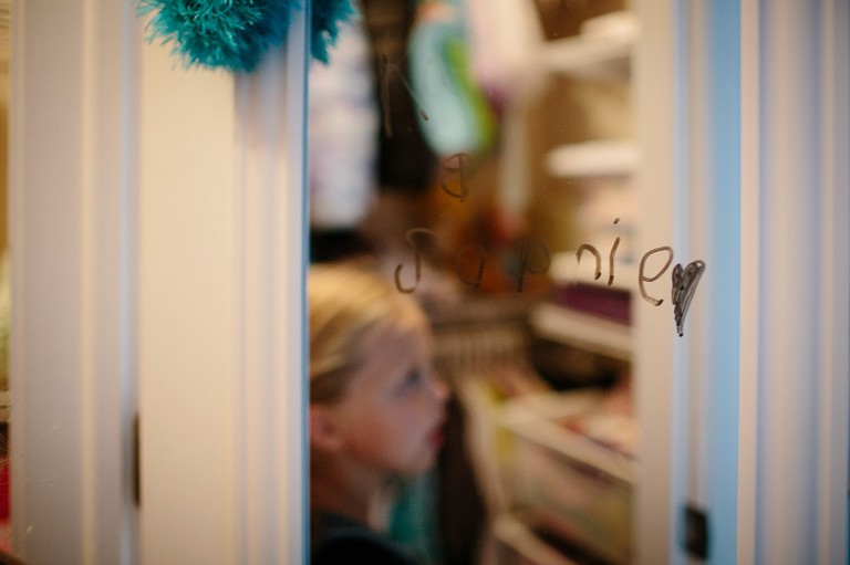 Reflection of 7 year old girl in mirror that she wrote her name on. 