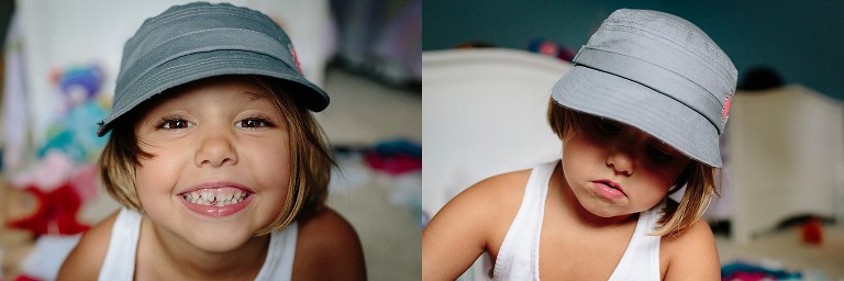 Smiling 5 year old girl wearing gray hat; girl concentrating on something. Serious. 