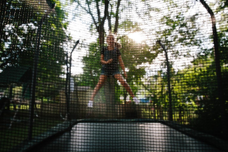 7 year old jumps on the trampoline in low light. 