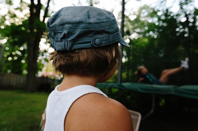 5 year old sister watches her 7 year old jump/fall on the backyard trampoline 