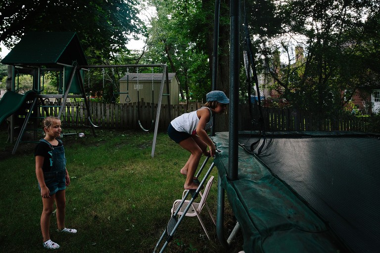 Girls climb onto backyard trampoline 