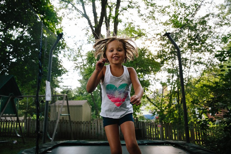 Camera aware smiling girl jumping on trampoline 