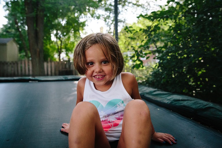 Camera aware smiling pic of girl on trampoline 