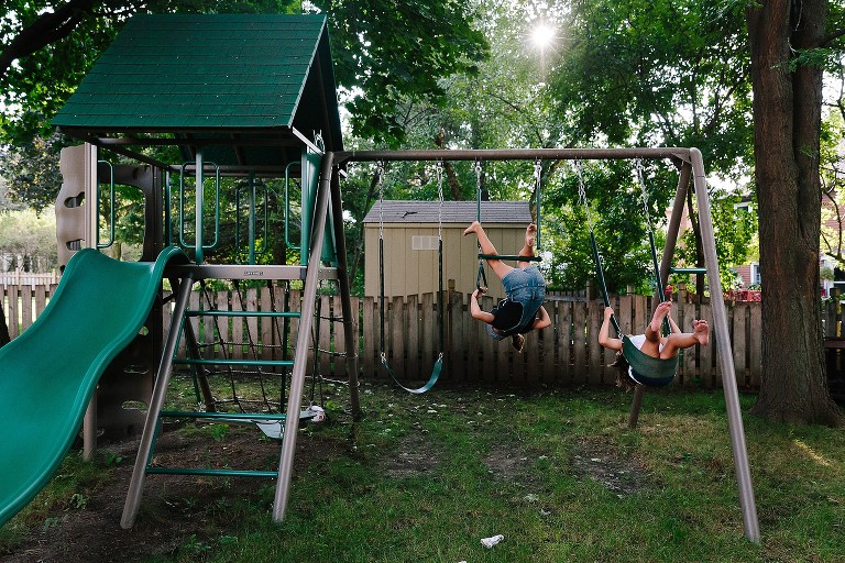 Two sister play on play structure in backyard 