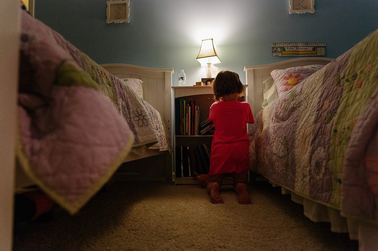 5 yo picks out bedtime book. Between two twin beds.