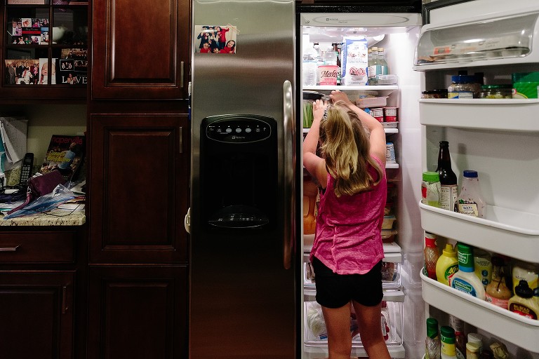 7 year old gets food out of refrigerator to make her lunch 