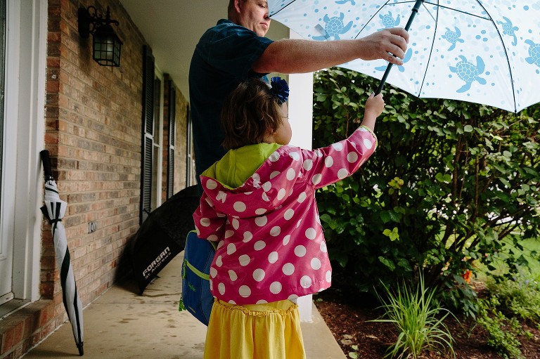 Dad holds out umbrella for daughter 