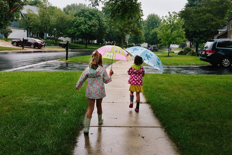 Girls walk to school in the rain. 