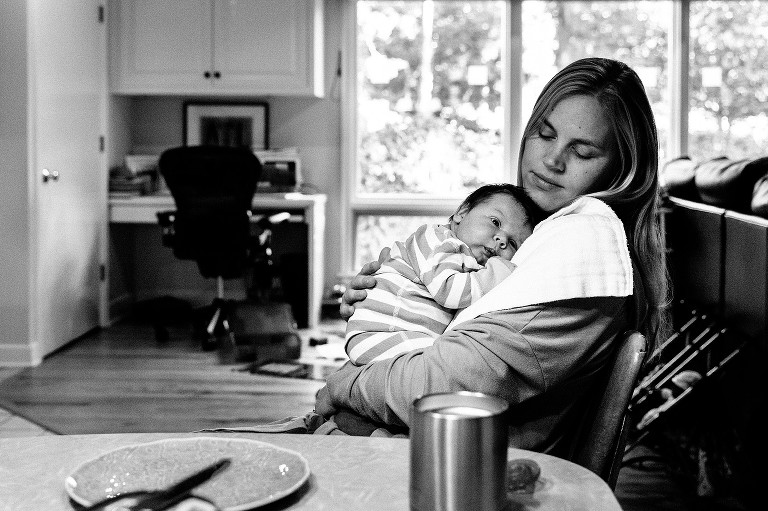 Mom holds newborn baby. Baby is alert. 