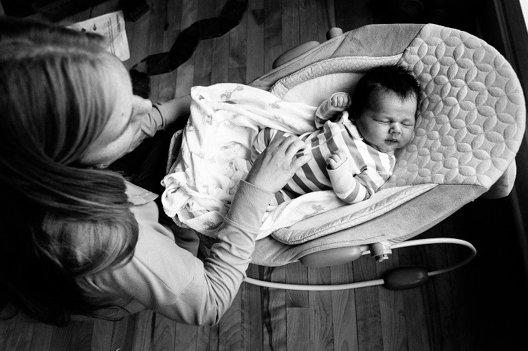 Top-down view of mother touching newborn son, sleeping. Black and white.