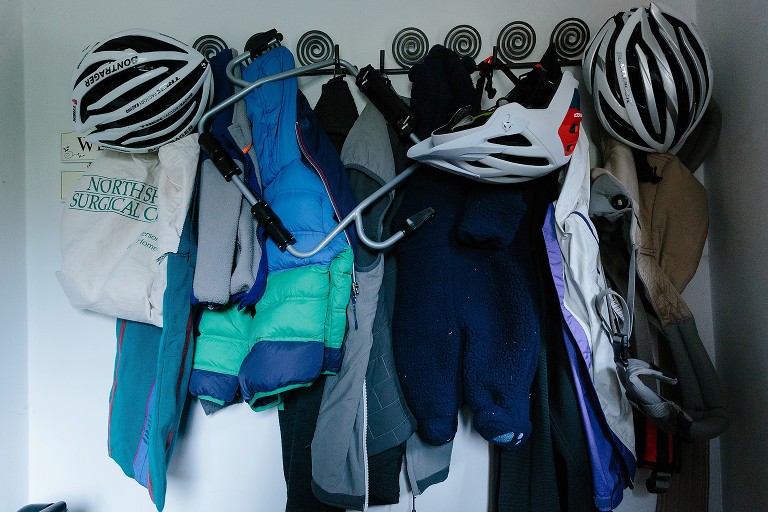 Coat hook with coats, bags, and bike helmets 
