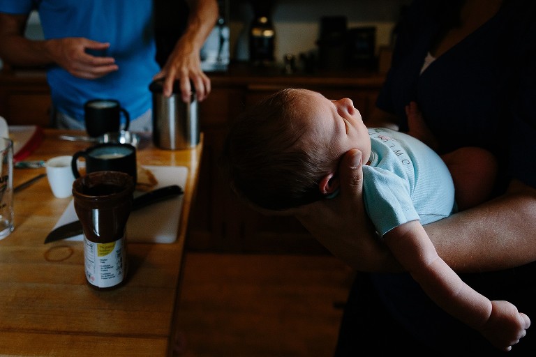 Highlights on baby's profile, dad's hands fall in the shadows in the background. 