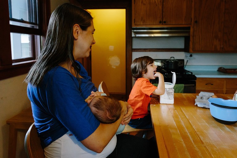 Mom breasfeeds daughter white son puts powdered sugar in his mouth. 