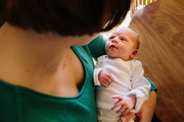 madison newborn looks at mother while being held, four