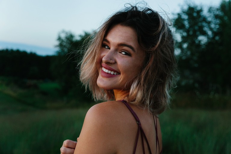 Young woman smiles for camera at dusk