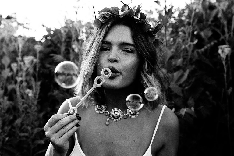 high school senior girl blows bubbles 