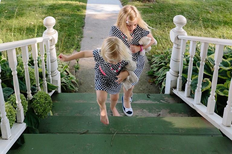 girls run up front porch together 