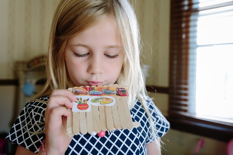 Girl plays pretend flute that she made 