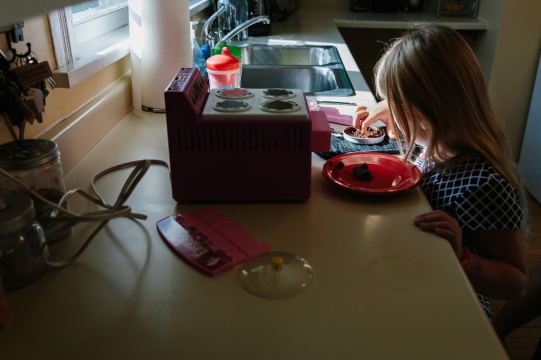 Girl gets chocolate cake out of Easy Bake Oven