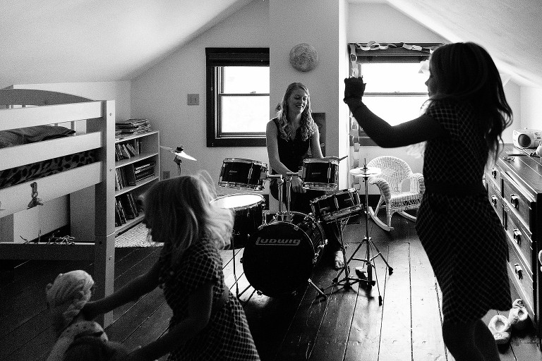 Mom plays drums while daughters dance 
