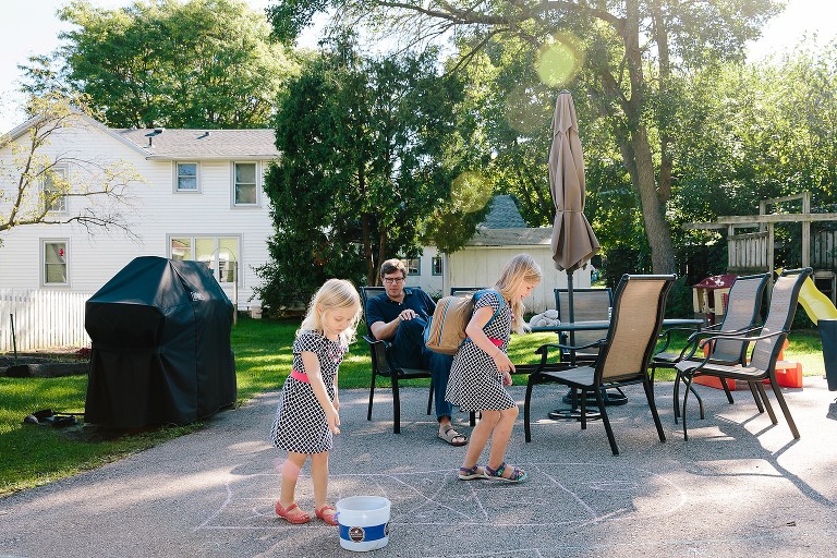 Girls play Hopscotch in the back yard. 