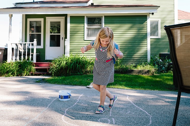 Girls play Hopscotch in the back yard. 