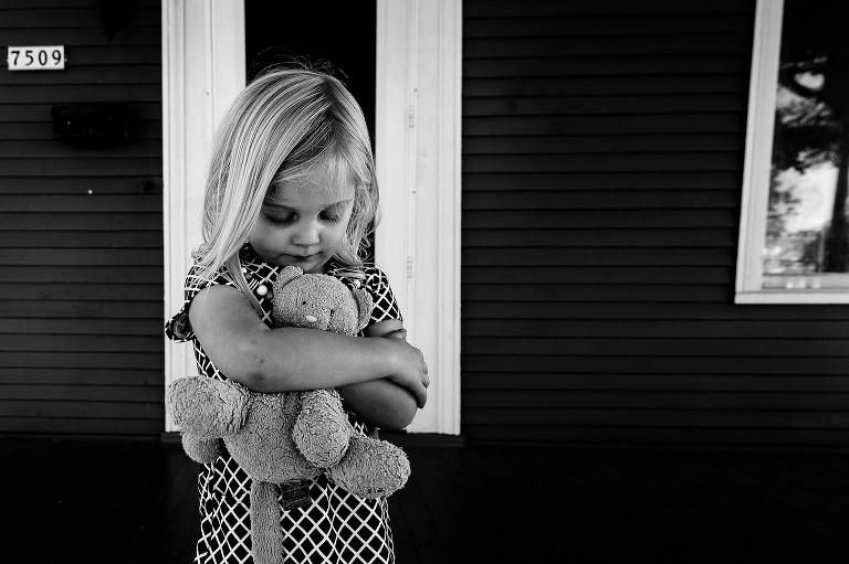 girl snuggles teddy bear 